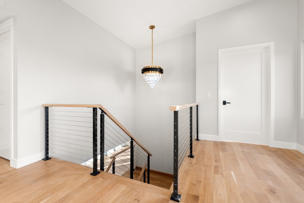 265 Varick Road Newton, MA 02468 - Photo 13 of 32 a view of a hallway with wooden floor and stairs
