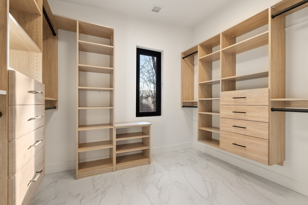 265 Varick Road Newton, MA 02468 - Photo 21 of 32 a view of walk in closet with clothes and shoes