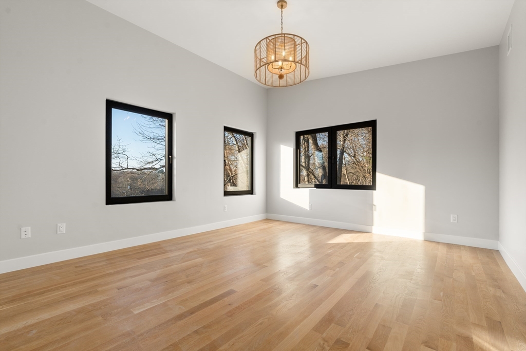 265 Varick Road Newton, MA 02468 - Photo 26 of 32 a view of an empty room with wooden floor and window