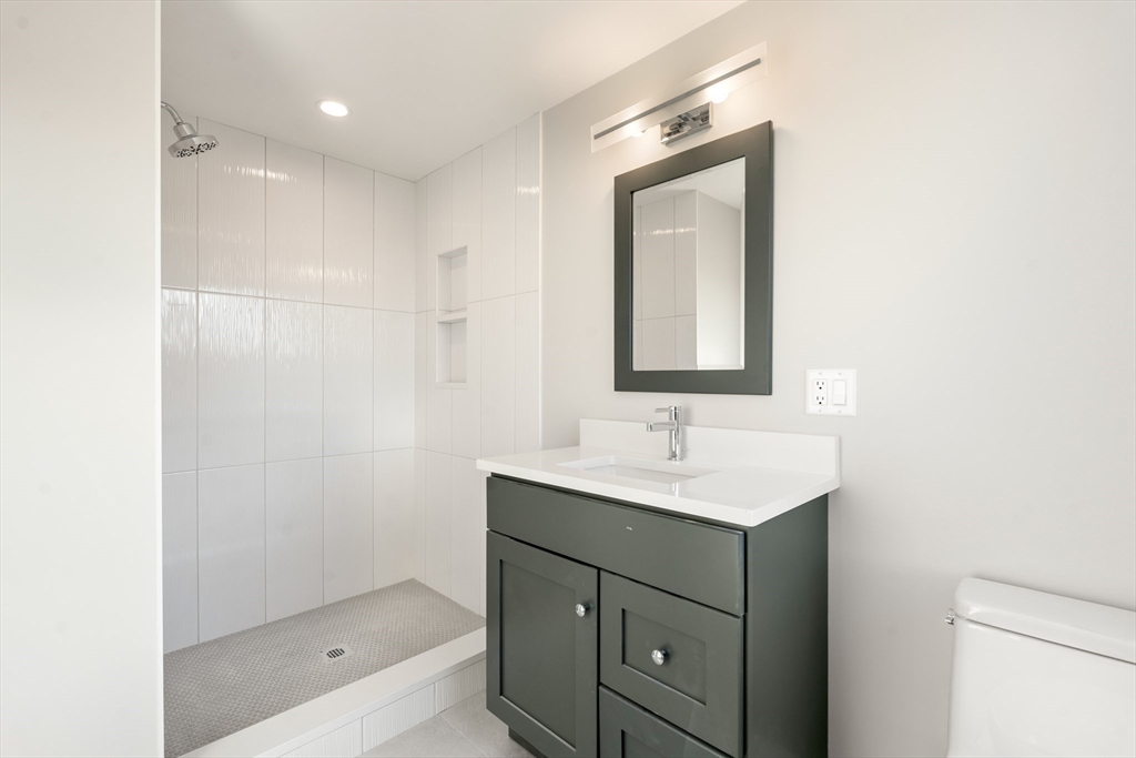 265 Varick Road Newton, MA 02468 - Photo 27 of 32 a bathroom with a sink a light fixture and a mirror