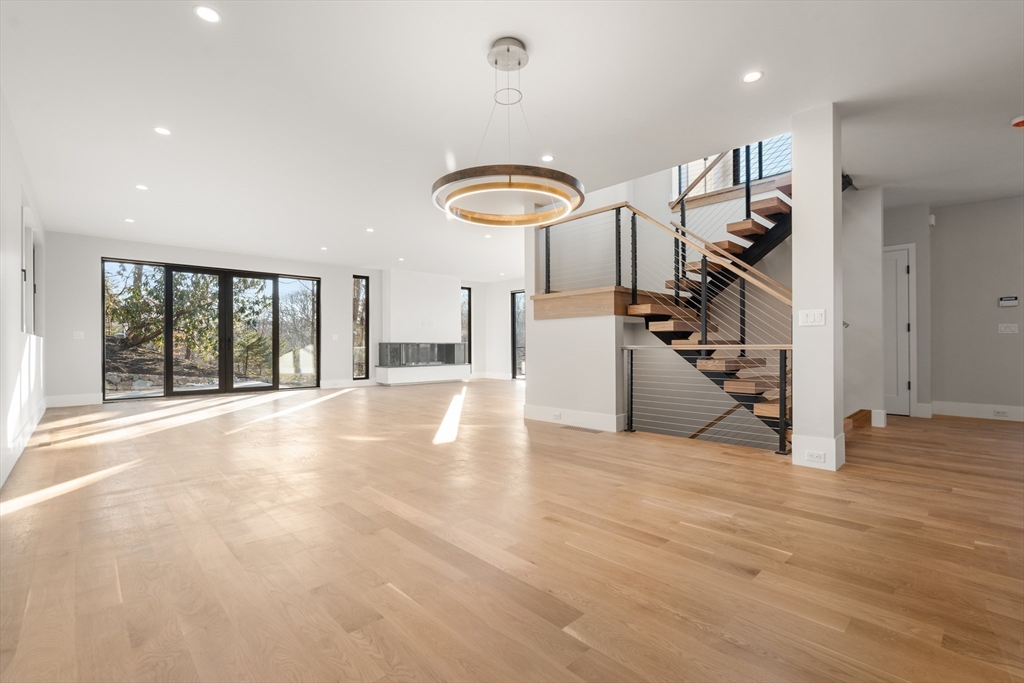 265 Varick Road Newton, MA 02468 - Photo 4 of 32 a view of an empty room with wooden floor and windows