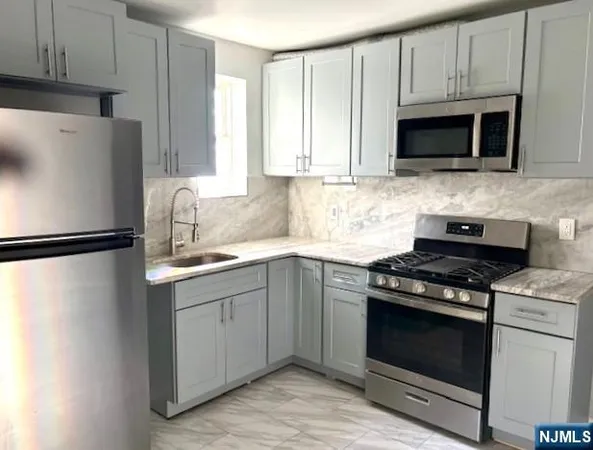 a kitchen with stainless steel appliances a stove a microwave and sink