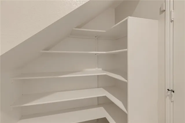 a view of walk in closet with empty racks