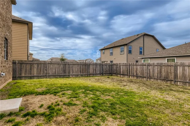 a view of backyard with wooden fence