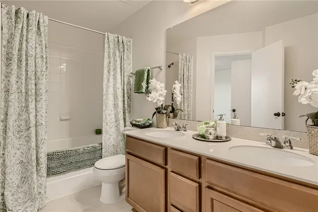 a bathroom with a granite countertop sink toilet mirror and shower