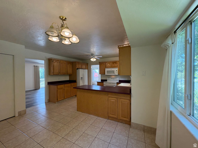 595 Meadowlark Road Orem, UT 84097 - Photo 17 of 87 Kitchen featuring tile flooring, wood cabinetry, built-in microwave, and an island with countertop seating