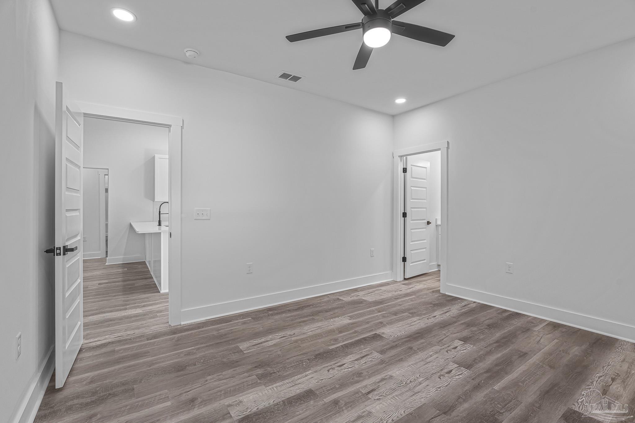 5005 Saufley Field Road Pensacola, FL 32526 - Photo 10 of 27 an empty room with wooden floor and a ceiling fan
