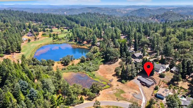 an aerial view of residential houses with outdoor space and trees