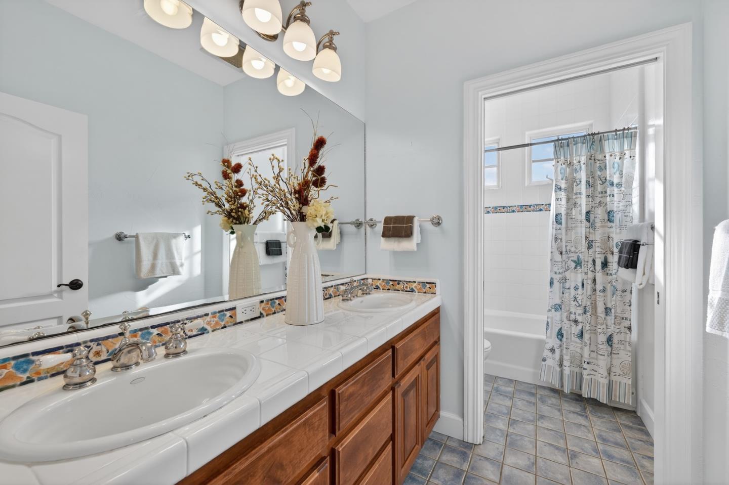 17599 Montebello Road Cupertino, CA 95014 - Photo 39 of 83 a bathroom with a sink a mirror and a shower
