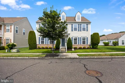a front view of a house with a yard and trees
