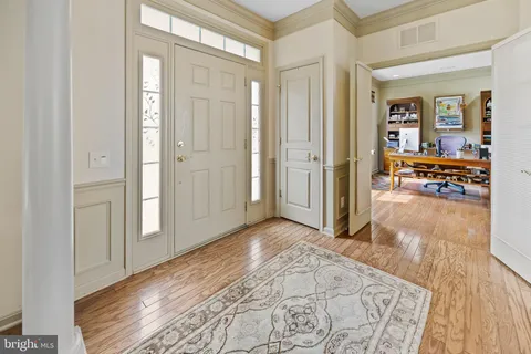 a view of a hallway with wooden floor and stairs