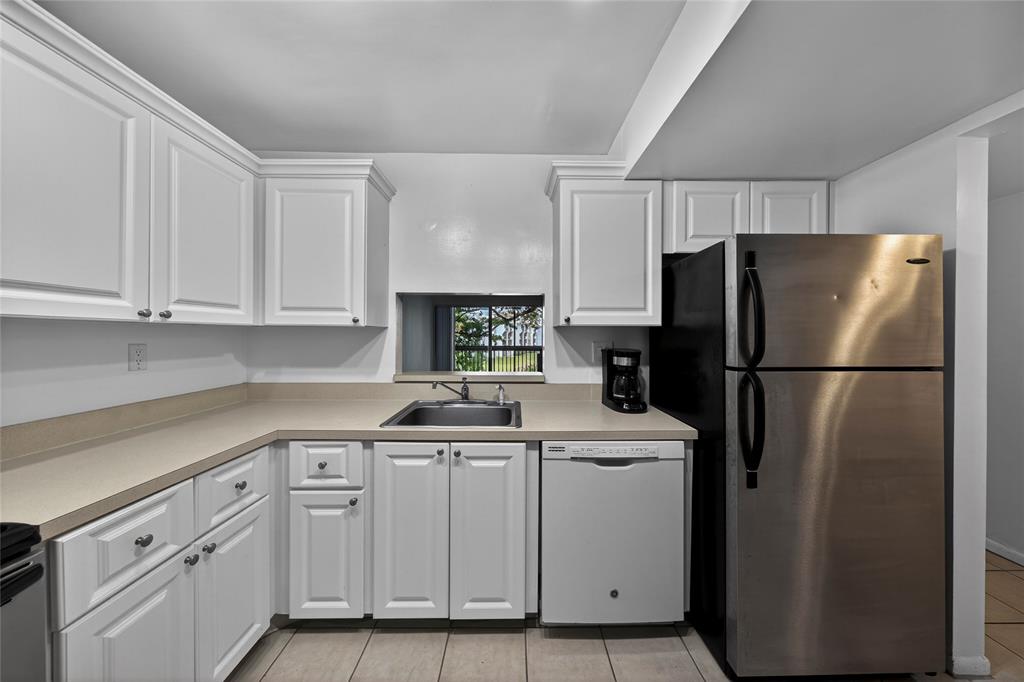 711 North Pine Island Road, Unit 319 Plantation, FL 33324 - Photo 13 of 27 a kitchen with white cabinets and refrigerator