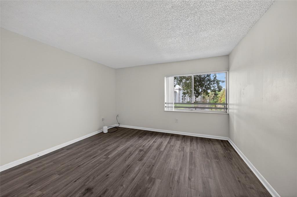 711 North Pine Island Road, Unit 319 Plantation, FL 33324 - Photo 23 of 27 an empty room with wooden floor and windows