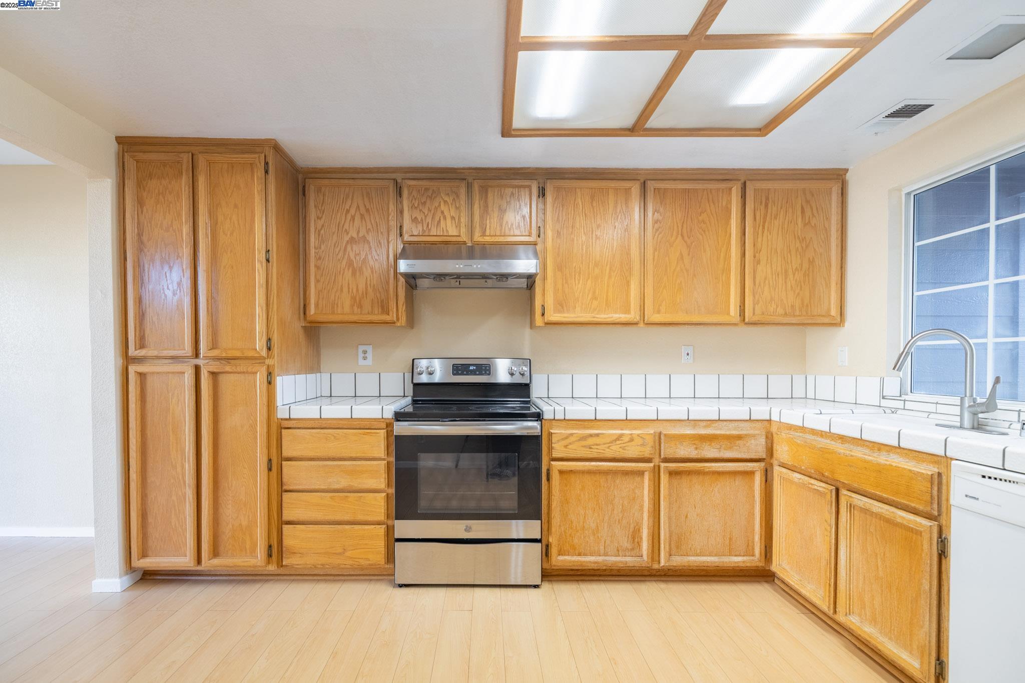 123 Pelican Loop Pittsburg, CA 94565 - Photo 11 of 60 a kitchen with a stove sink and cabinets