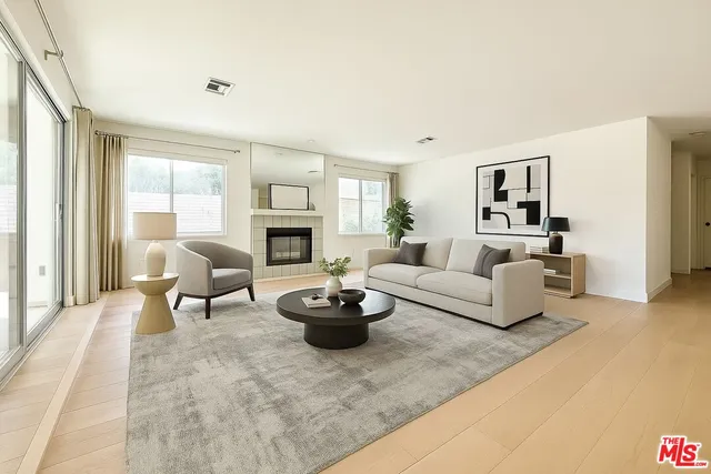 a living room with furniture a fireplace and a large window