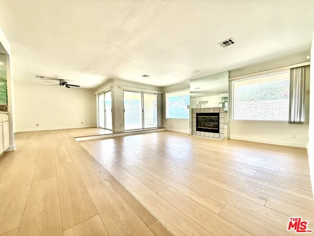 an empty room with wooden floor and fireplace