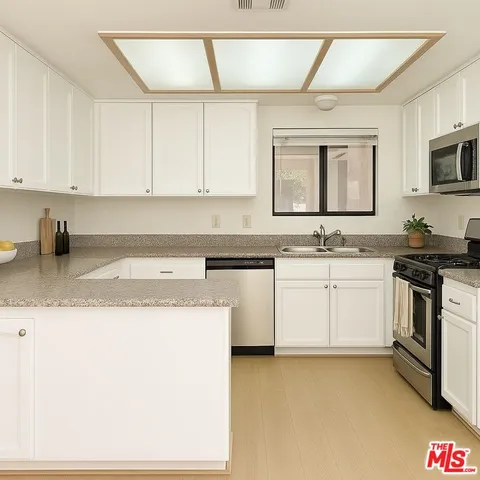 a kitchen with granite countertop white cabinets and white appliances