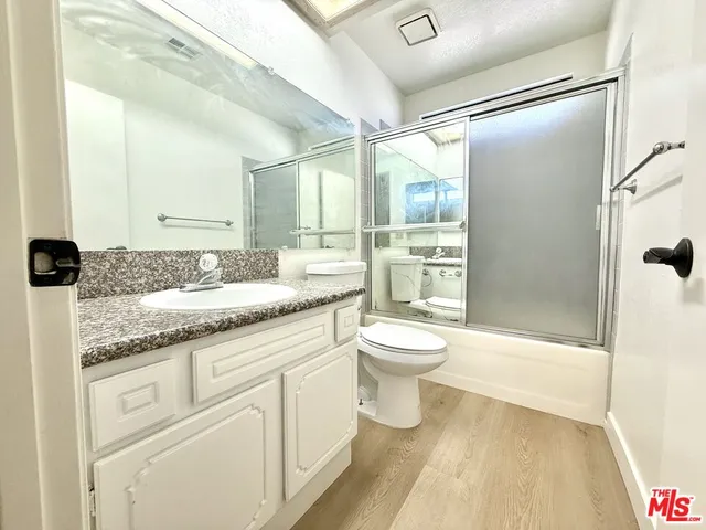 a bathroom with a granite countertop sink toilet and shower