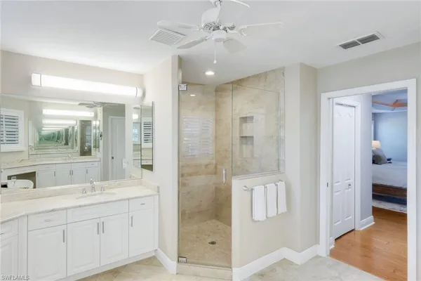 a bathroom with a double vanity sink mirror and shower