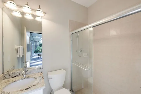 a bathroom with a sink vanity mirror and toilet