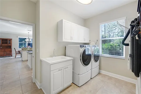 a utility room with cabinets dryer and washer