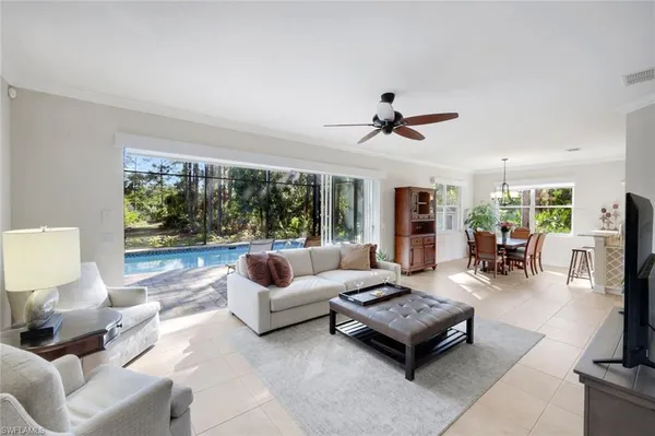 a living room with furniture ceiling fan and a large window