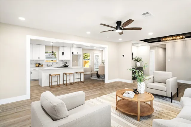 a living room with furniture and a dining table with kitchen view