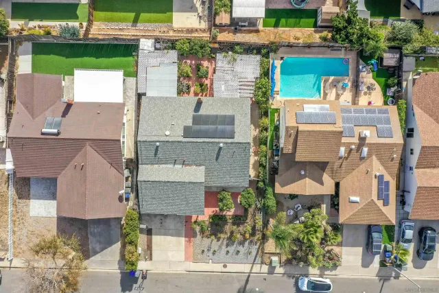 an aerial view of a house with a yard and wooden fence