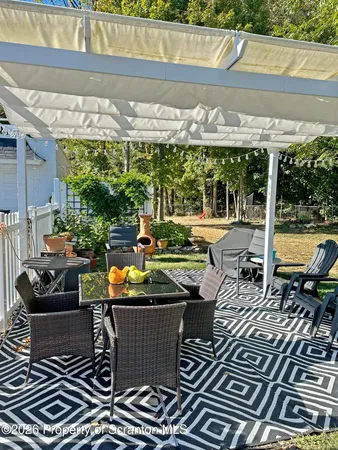 a view of a patio with a table chairs and a yard