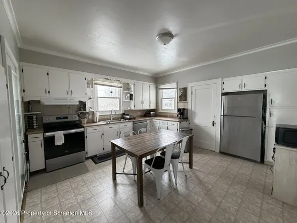 a kitchen with refrigerator cabinets and wooden floor