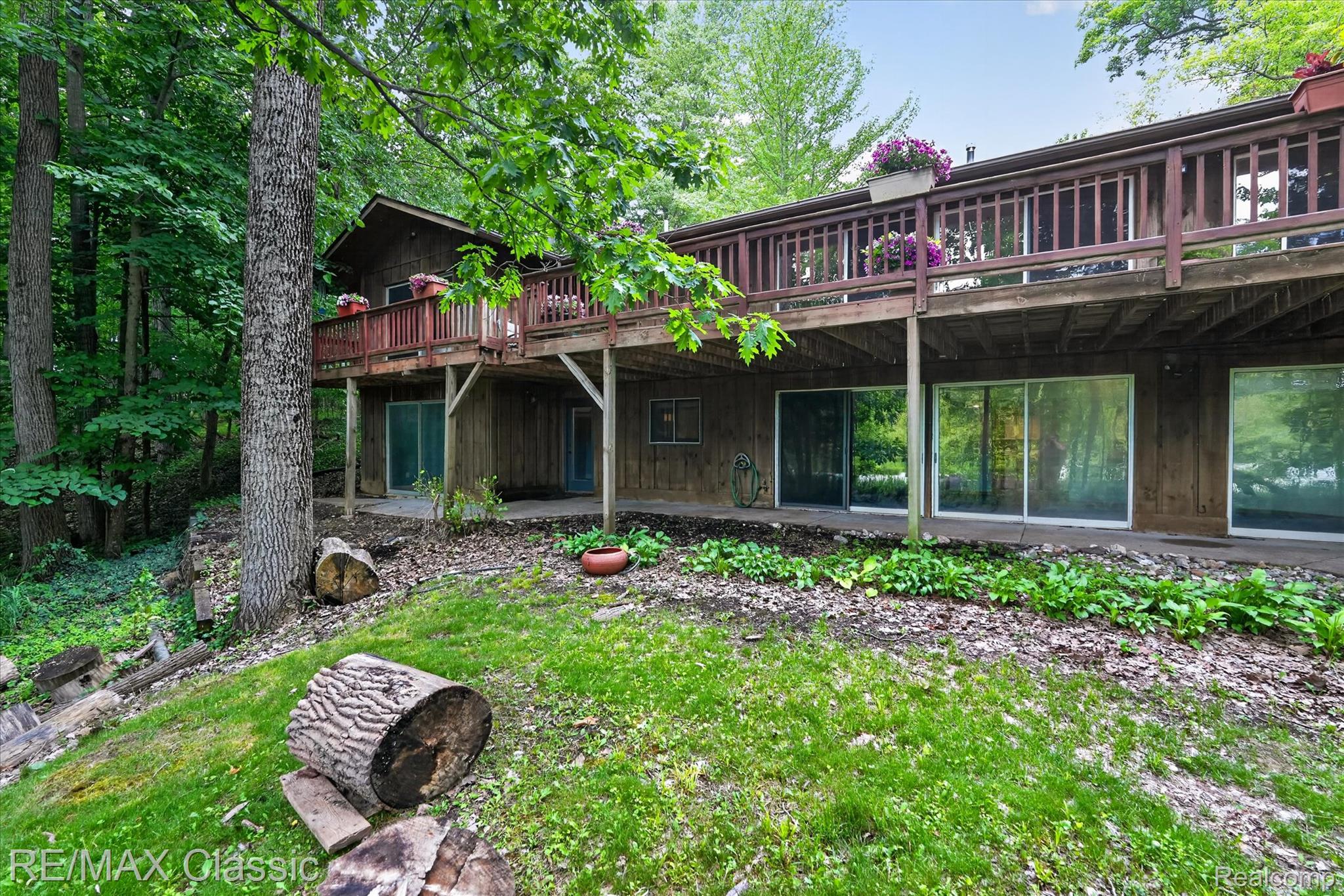 12189 Gage Road Holly, MI 48442 - Photo 53 of 69 Wood-sided dwelling featuring a full-width upper deck with wood railing, supported by columns