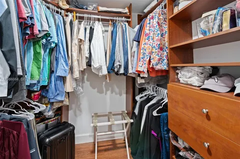 a view of walk in closet with clothes