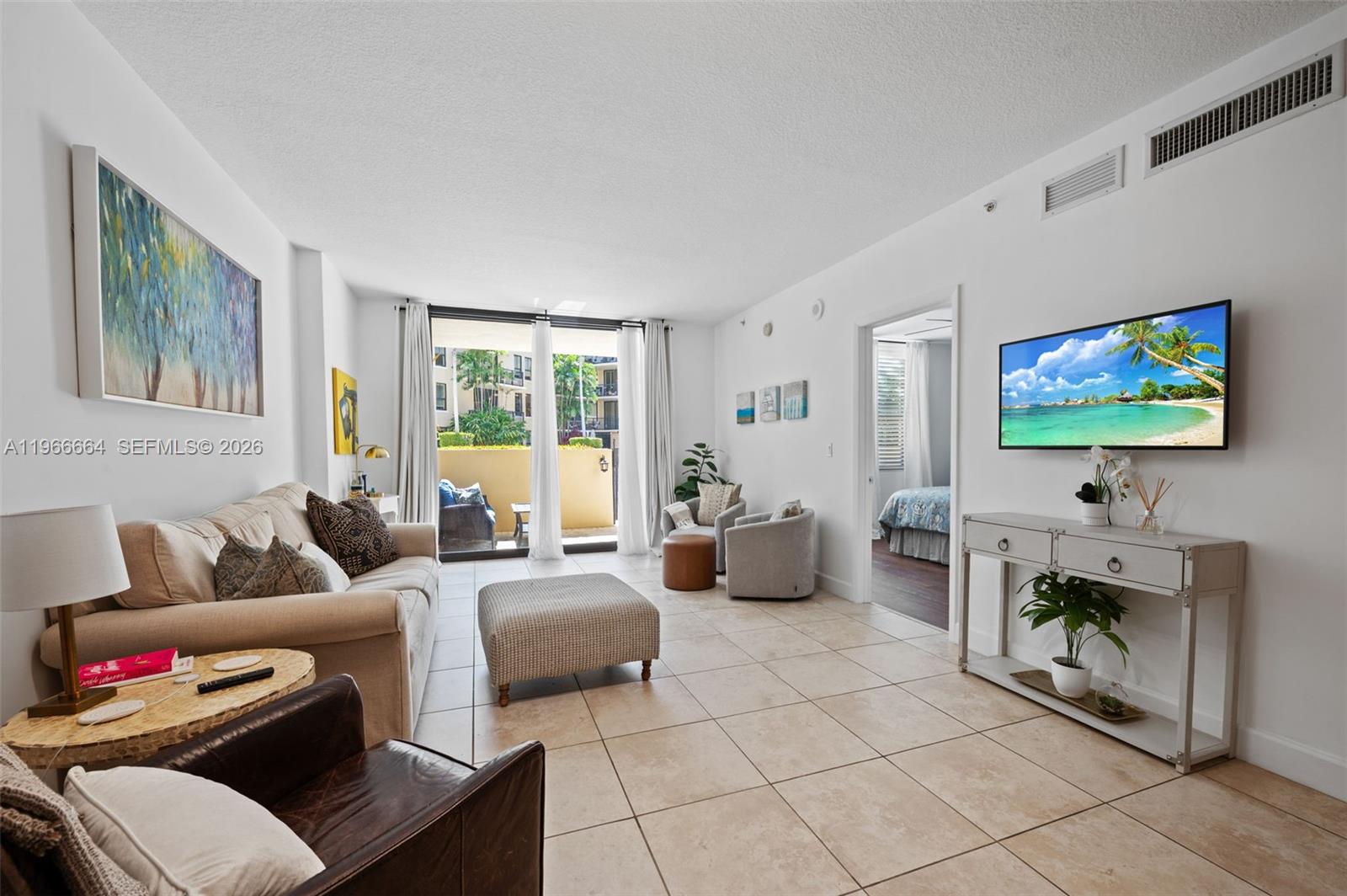 55 Merrick Way, Unit 507 Coral Gables, FL 33134 - Photo 3 of 28 a living room with furniture and a flat screen tv