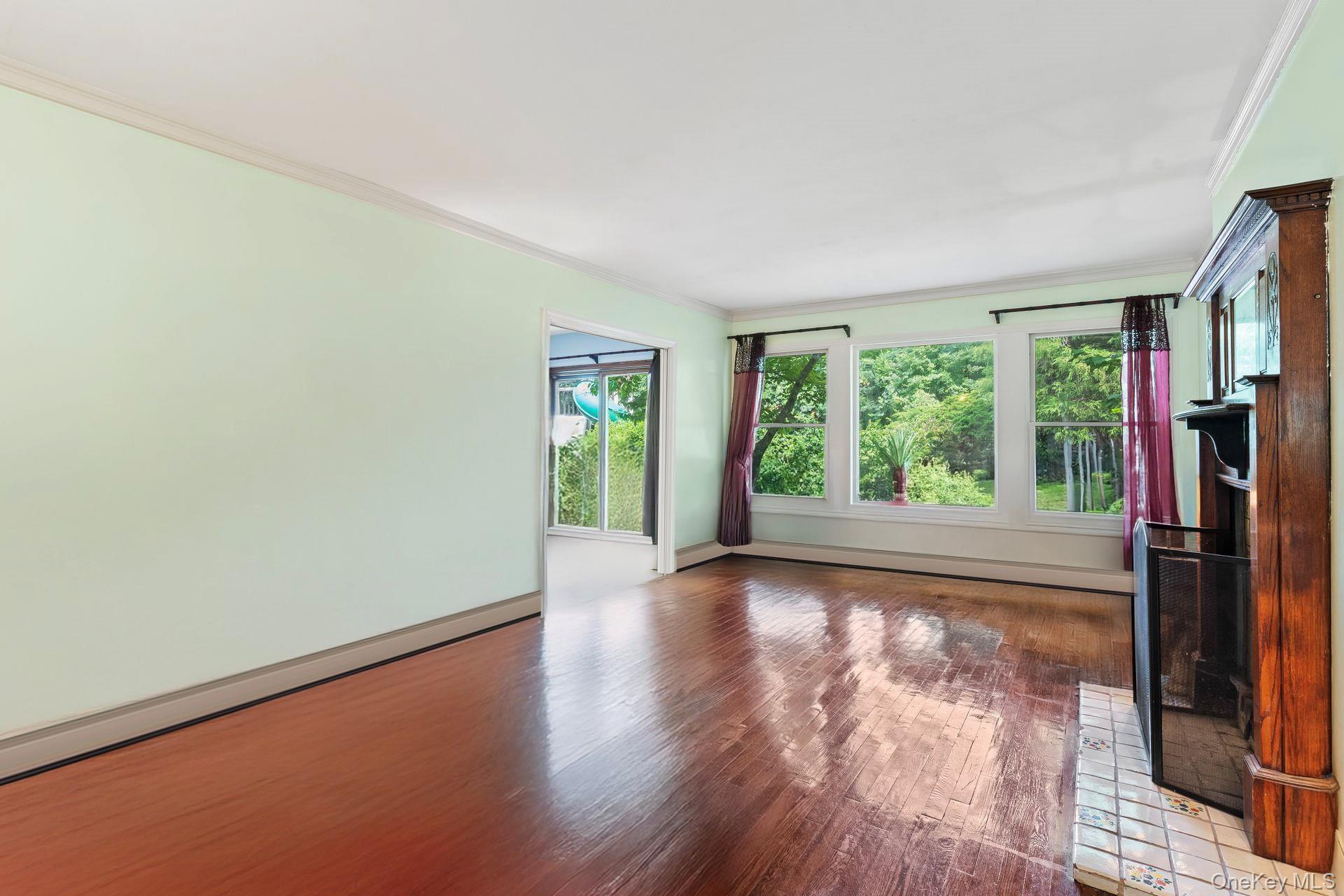 13 Whitney Circle Glen Cove, NY 11542 - Photo 9 of 44 Unfurnished living room featuring ornamental molding, wood finished floors, and a baseboard radiator