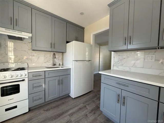 a kitchen with a refrigerator stove and white cabinets