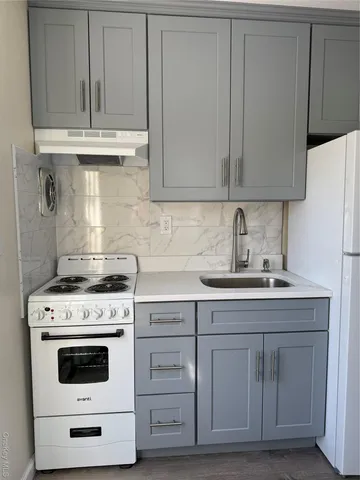 a kitchen with granite countertop white cabinets and white appliances