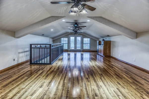 a view of a room with wooden floors and ceiling fan