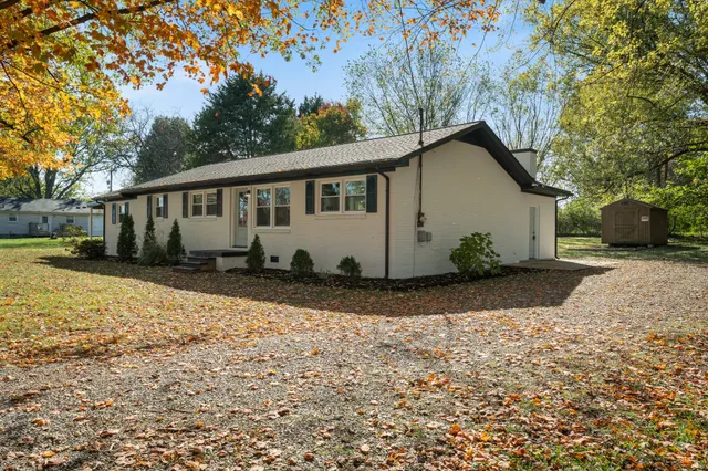 a view of a house with a yard covered with snow in front of it