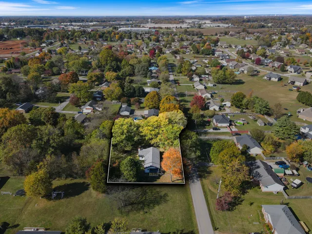 an aerial view of a residential houses covered in trees