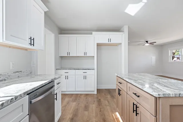 a kitchen with granite countertop a sink stove and refrigerator