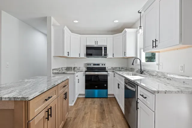 a kitchen with granite countertop white cabinets and white appliances