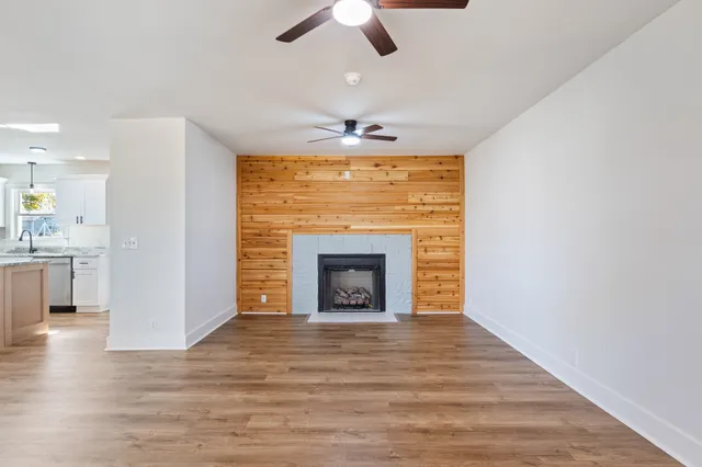 a view of an empty room with a fireplace and a window