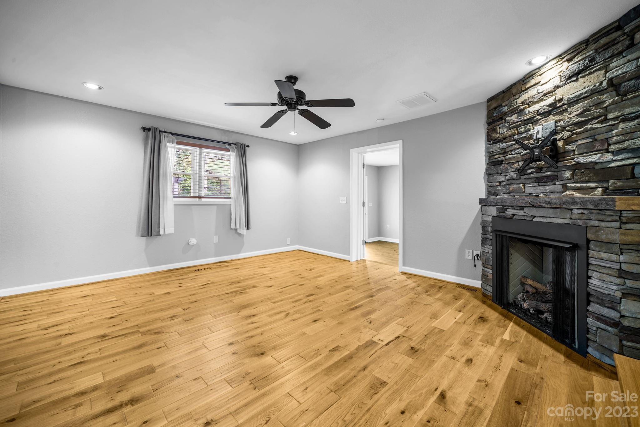 309 Sheldon Street Hudson, NC 28638 - Photo 15 of 40 a view of empty room with wooden floor and fireplace