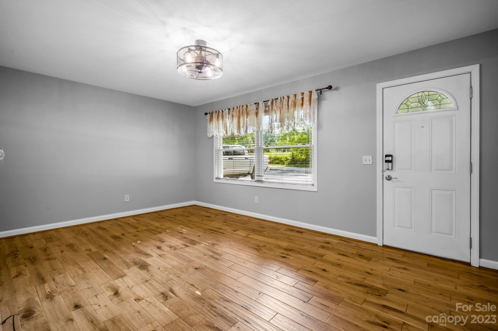 309 Sheldon Street Hudson, NC 28638 - Photo 3 of 40 a view of an empty room with window and wooden floor
