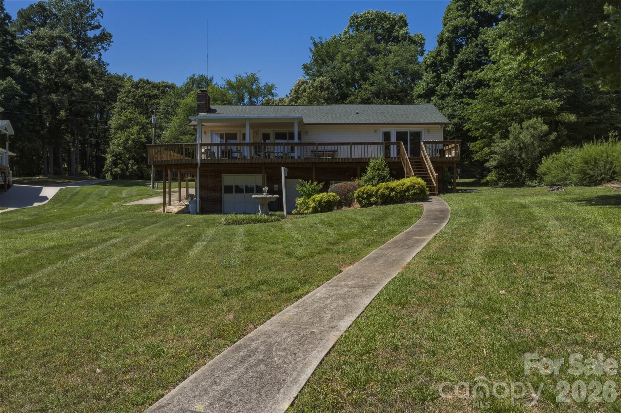 8226 Normandy Road Denver, NC 28037 - Photo 13 of 29 a view of a house with a big yard potted plants and a large tree