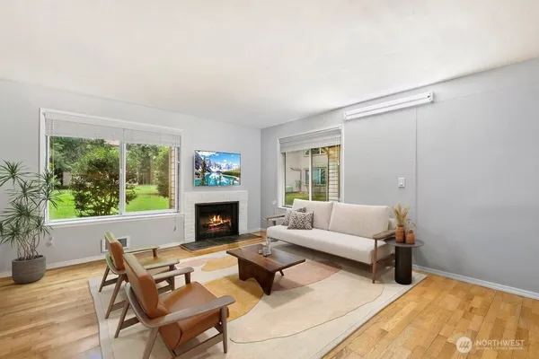 a living room with furniture a fireplace and a window