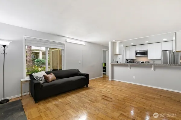 a living room with furniture and a kitchen with sink