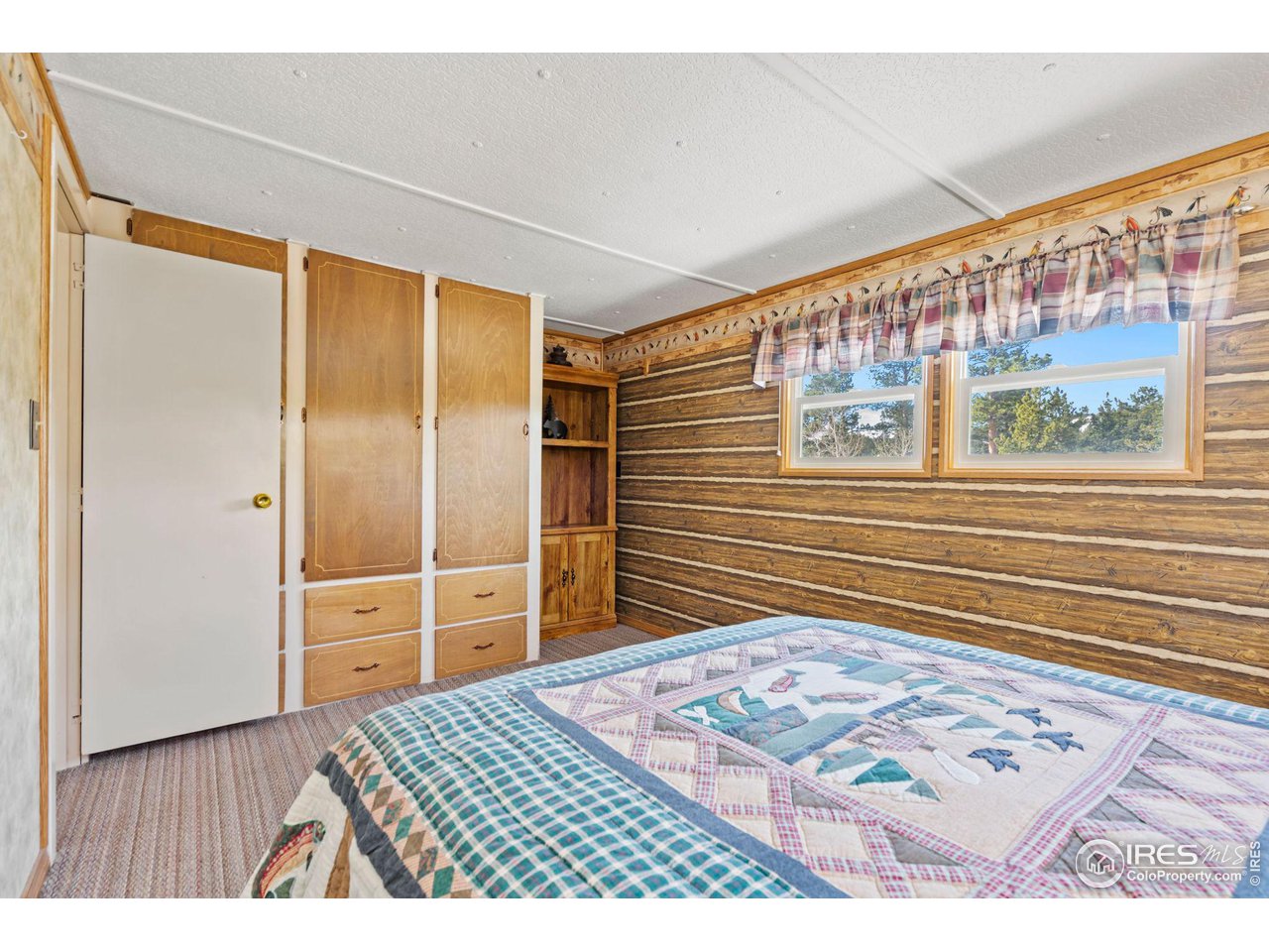 36 Comanche Circle Red Feather Lakes, CO 80545 - Photo 17 of 40 a bedroom with a bed and wooden floor