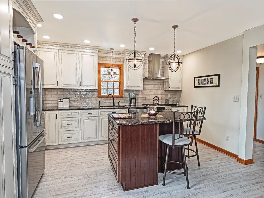 108 Metzler Road Apollo, PA 15613 - Photo 5 of 25 a kitchen with stainless steel appliances granite countertop a stove top oven a sink dishwasher a dining table and chairs with wooden floor