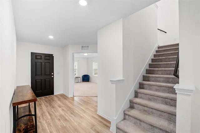 a view of a kitchen with refrigerator and wooden floor